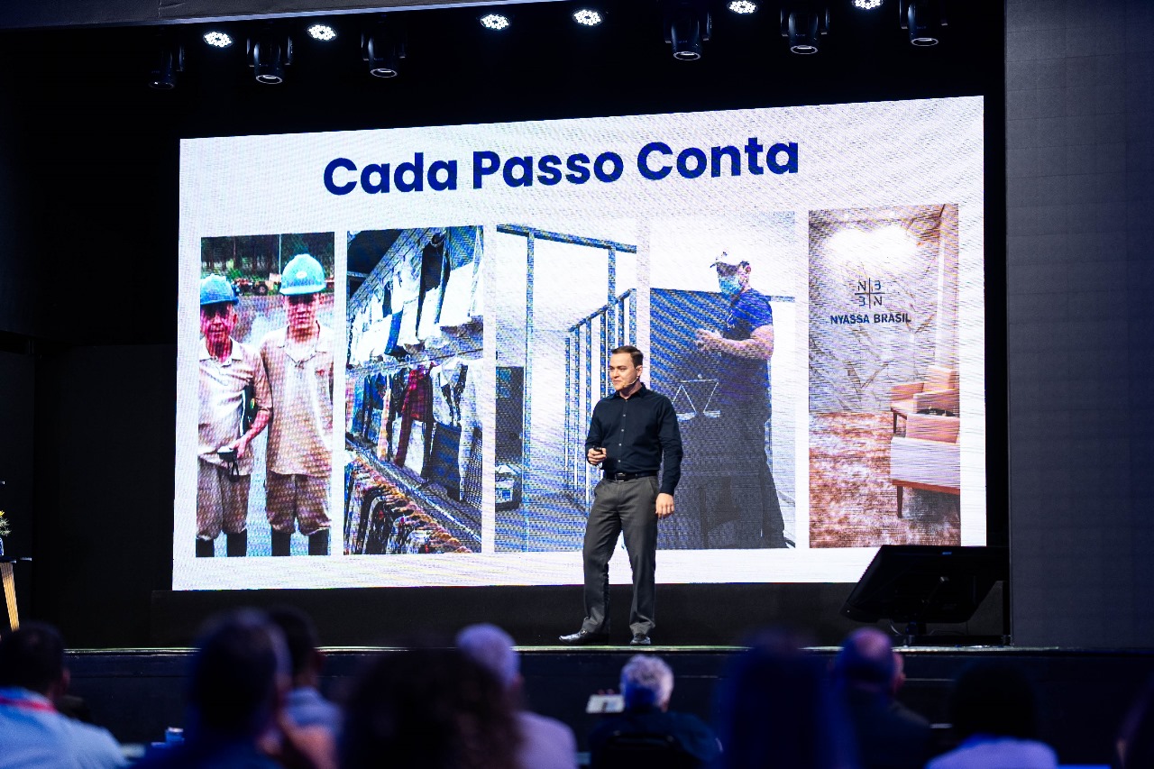 Gustavo Brasil em palestra no palco para grande público